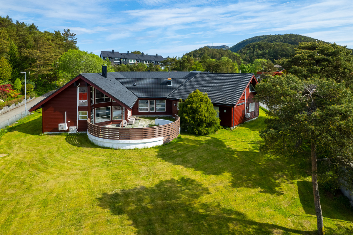 Dronebilde av hagen til Bønesskogen, med fasaden av huset med i bildet. 